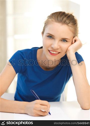 picture of happy teenage girl with pen and paper