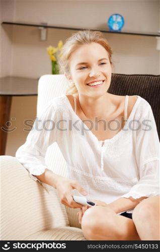 picture of happy teenage girl with TV remote
