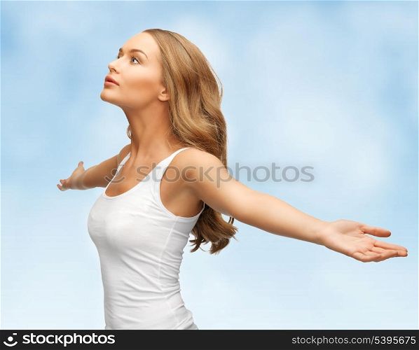 picture of happy woman spreading hands over blue sky.