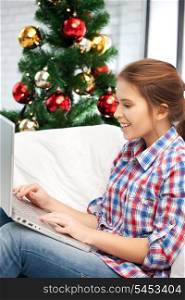 picture of happy woman with laptop computer and christmas tree.