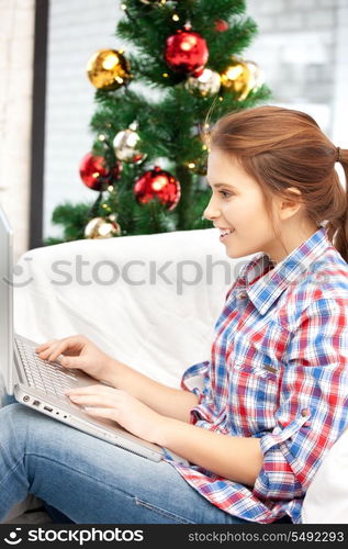 picture of happy woman with laptop computer and christmas tree