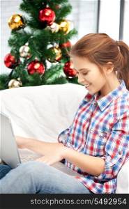 picture of happy woman with laptop computer and christmas tree