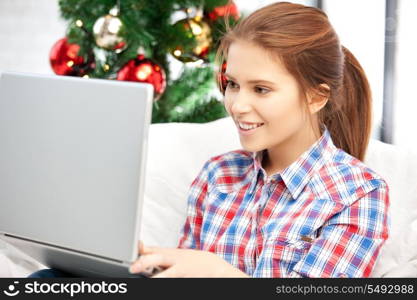 picture of happy woman with laptop computer and christmas tree