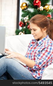 picture of happy woman with laptop computer and christmas tree