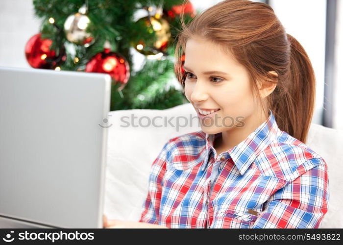 picture of happy woman with laptop computer and christmas tree