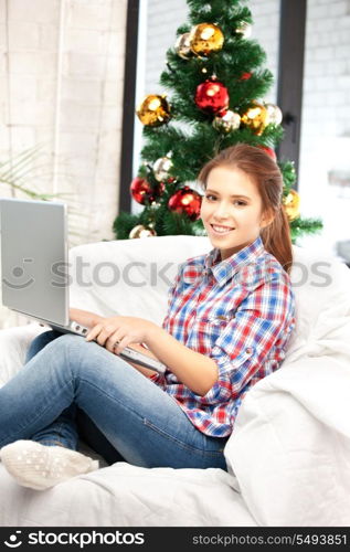 picture of happy woman with laptop computer and christmas tree