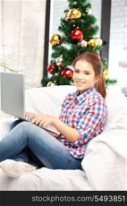 picture of happy woman with laptop computer and christmas tree