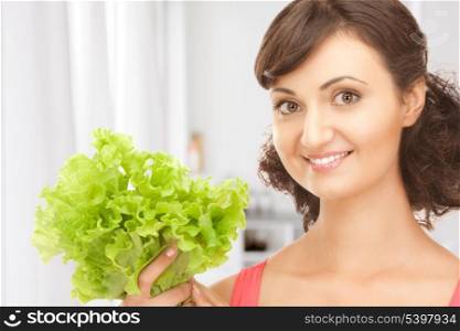 picture of happy woman with lettuce in kitchen