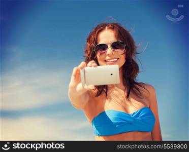 picture of happy woman with phone on the beach