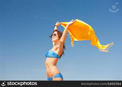 picture of happy woman with yellow sarong on the beach.