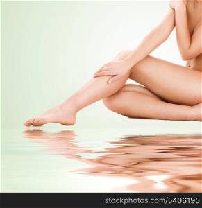 picture of healthy naked woman legs over green background