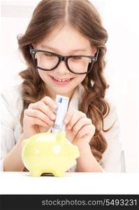 picture of little girl with piggy bank and money