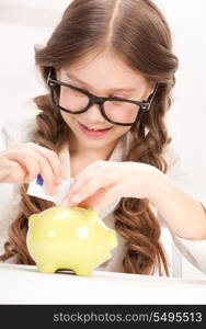 picture of little girl with piggy bank and money