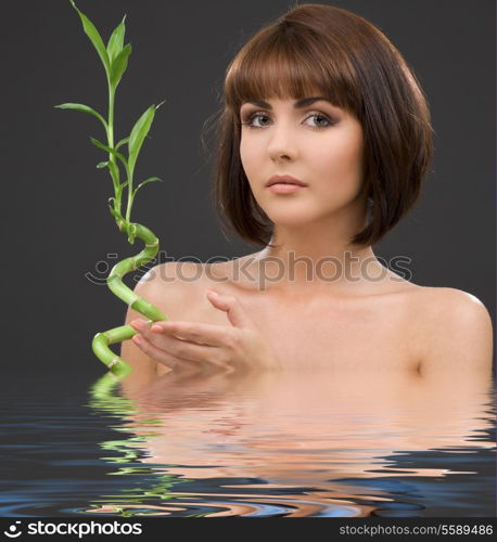 picture of lovely brunette with bamboo in water