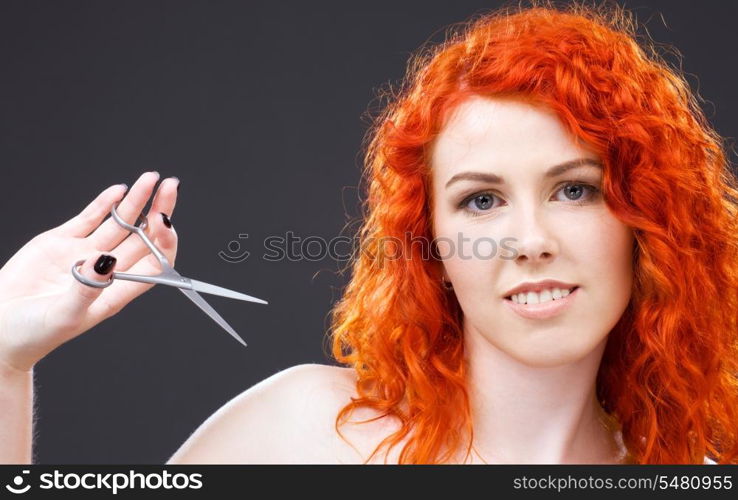 picture of lovely redhead with scissors over grey