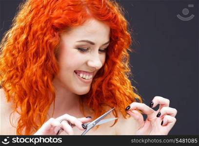 picture of lovely redhead with scissors over grey