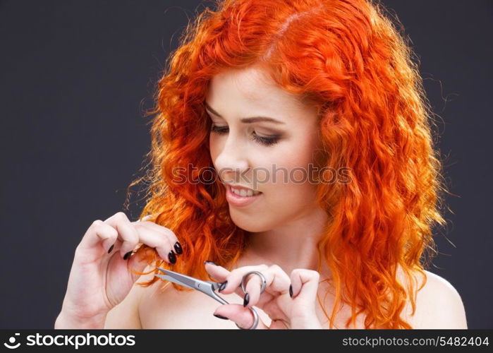 picture of lovely redhead with scissors over grey