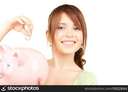 picture of lovely teenage girl with piggy bank and coin
