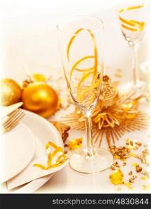 Picture of luxury festive table setting, closeup image of beautiful white utensil decorated with golden shiny toys and candle, romantic dinner in restaurant, New Year eve, Christmas holiday