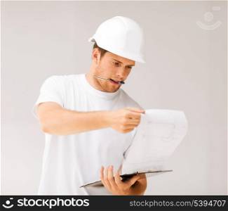 picture of male architect in helmet looking at blueprint