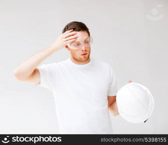 picture of male architect in safety glasses taking off helmet