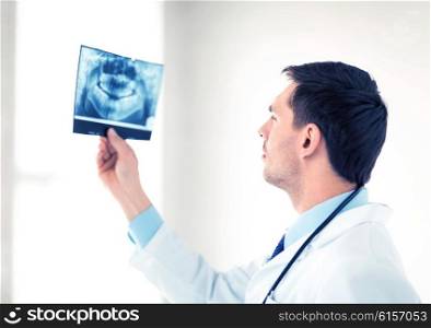 picture of male doctor or dentist looking at x-ray. male doctor or dentist looking at x-ray