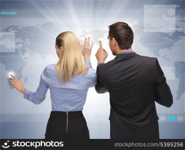 picture of man and woman working with virtual touch screens.