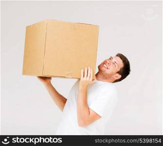 picture of man carrying carton heavy box