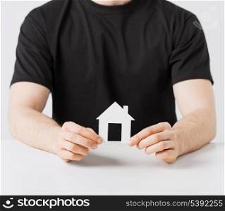 picture of man hands holding paper house