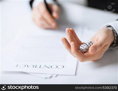picture of man hands with gambling dices signing contract