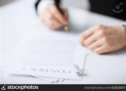 picture of man hands with gambling dices signing contract