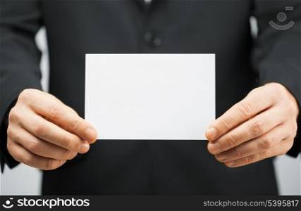 picture of man in suit holding blank card.