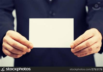 picture of man in suit holding blank card.