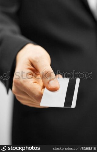 picture of man in suit holding credit card.
