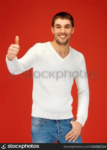 picture of man in warm sweater showing thumbs up.