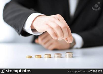 picture of man putting stack of coins into one row