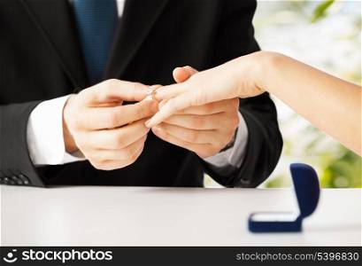 picture of man putting wedding ring on woman hand