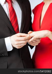 picture of man putting wedding ring on woman hand