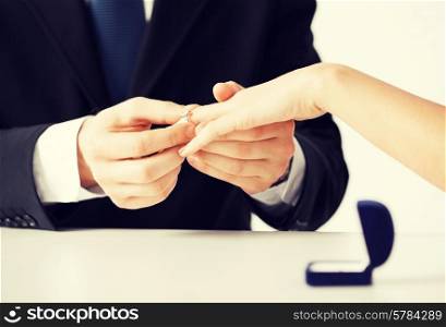 picture of man putting wedding ring on woman hand