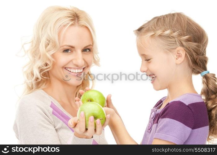 picture of mother and little girl with green apple (focus on girl)