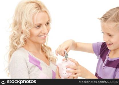 picture of mother and little girl with piggy bank (focus on woman)