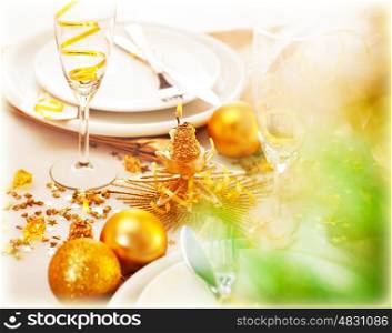 Picture of New Year table decorations, luxury festive table setting, romantic holiday dinner, white utensil adorned with golden shiny baubles, glasses for traditional Christmastime drink, champagne