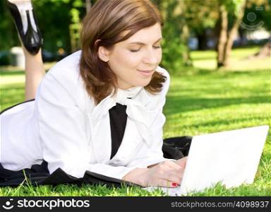 picture of office lady with laptop computer laying on the grass