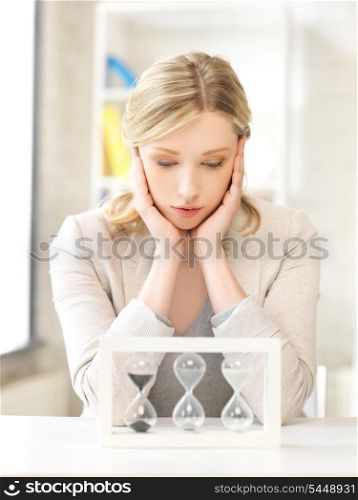 picture of pensive businesswoman with sand glass