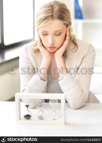 picture of pensive businesswoman with sand glass