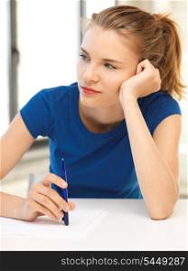 picture of pensive teenage girl with pen and paper