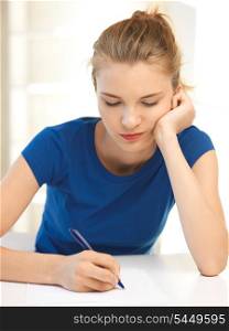 picture of pensive teenage girl with pen and paper
