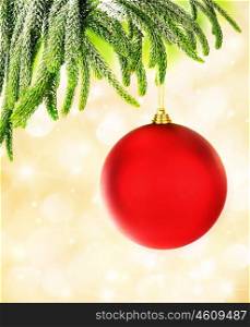 Picture of red Christmastime bubble hanging on fresh green fir branch, holiday decorations isolated on yellow blur background, decorated Christmas tree, New Year ornament, festive glass ball