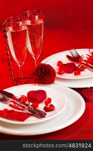 Picture of red holiday table decoration, white luxury dinnerware served with knife and fork, two glass for champagne, sparkling wine, romantic dinner, Valentines day, romance and love concept