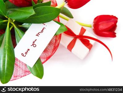 Picture of red tulips flower with greeting postcard on fresh green leaves and gift box isolated on white background,festive border, happy mothers day, spring season, romance and love concept